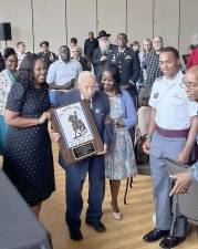 Dr. Aundrea Matthews (left) presents a plaque signed by original members of the Buffalo Soldiers to Rev. Robert W. Dixon, the last living Buffalo Soldier, who turns 100 later this month.