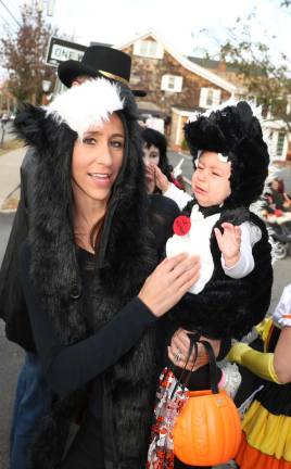 Diana Woglom and her baby skunk, Madelyn, who doesn't seem happy about dressing up for Halloween.