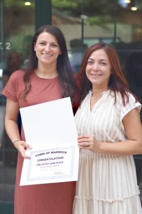 Holly McPherson and Venus Lageman hold their grand opening certificate.