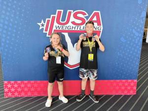 Sadie Cirbus and Landon Tarazona show off the weightlifting medals they won at the USA Weightlifting 2024 National Youth Championships in June.