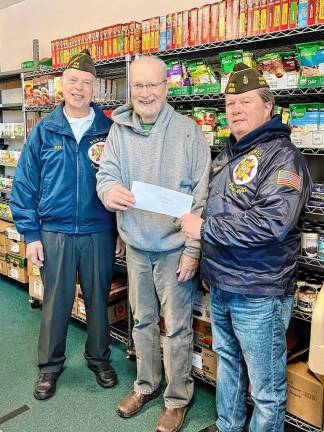 Veteran Bryan Kidney presents a check to volunteer Charles Hemstreet, along with veteran Bill Metzger.