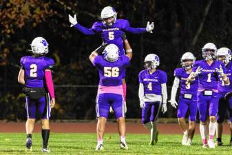 Warwick’s Ryan Sullivan, #5, gets a lift from team captain Grant Havell, #56, after scoring one of his three touchdowns against Washingtonville.