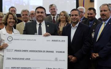 Pictured from left to right are: Annette Kahrs, President of the Tri-County Partnership coalition and Director of Hope Not Handcuffs Hudson Valley, Legislator Rob Sassi, Orange County Executive Steven M. Neuhaus and District Attorney David M. Hoovler at the Legislative meeting on Thursday, Aug. 1. In the background are members of the Orange County Legislature.