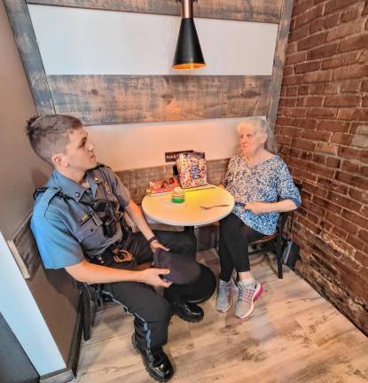 Town of Warwick Police Officer Ryan King enjoys a conversation with Diane Wozniak during the May 20 “Coffee with a Cop” event at Café e Dolci.