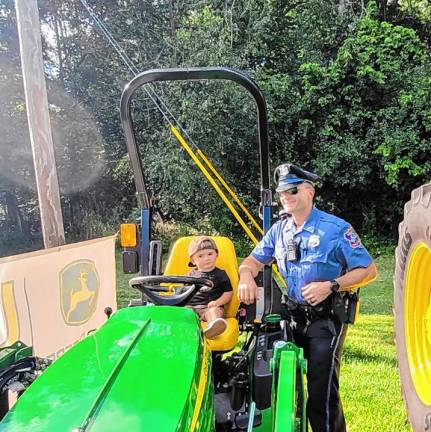 At last year’s National Night Out, Nash climbs onto a tractor with the help of his dad, Warwick Police Officer Tim Horton.<b> </b>