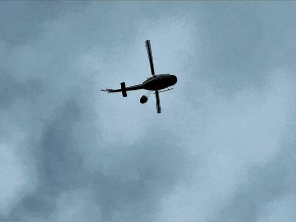 A helicopter carries water to the fires. (Photo by Denise von Wilke)