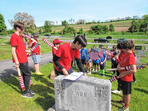 Troop 45 scouts place flags at veterans’ graves at the Warwick Cemetery.