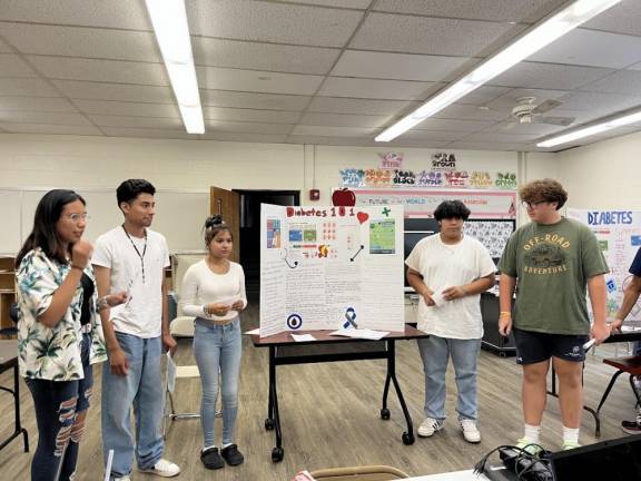 Program attendees hold healthcare presentations on diabetes.