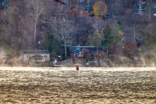 A helicopter picks up water from Greenwood Lake to drop on the Jennings Creek Wildfire on Tuesday, Nov. 12.