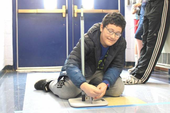 A student prepares to launch a straw rocket.