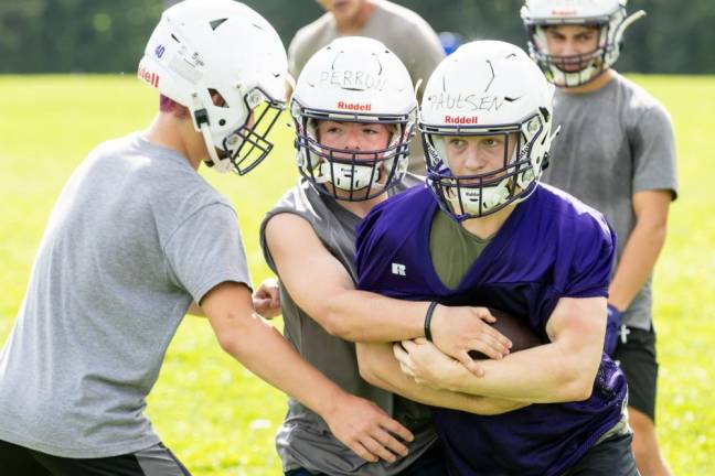 Players run through drills on the first day of football practice on Aug. 19, 2024.