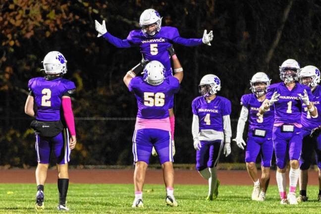 Warwick’s Ryan Sullivan, #5, gets a lift from team captain Grant Havell, #56, after scoring one of his three touchdowns against Washingtonville.