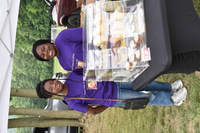 Nadine Whighd-Webb, owner of Flower Cakes By Nadine, poses with her daughter Nya, left, in the farmers market area.