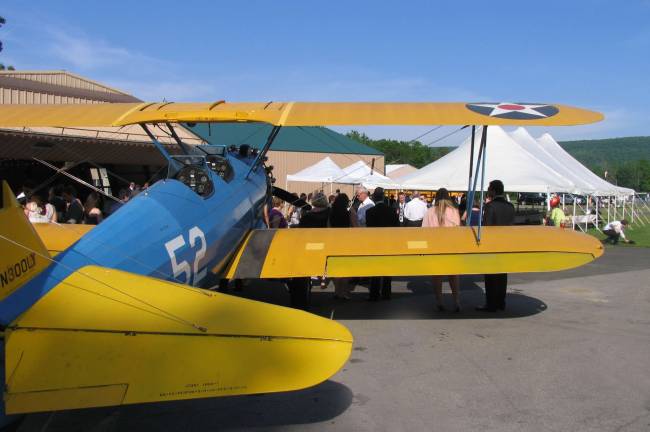 About 150 wedding guests enjoyed a banquet under a huge tent. They were surrounded by vintage airplanes with historic manufacturers' designations like Stearman P17, Boeing P23 and Tiger Moth.