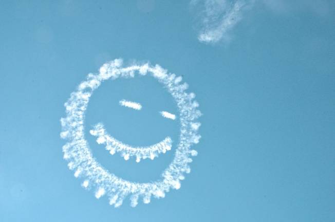 A smiley face created by smoke is representative of the smiling crowds of people watching the air show.