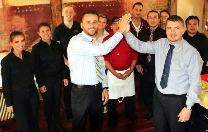 Photo by Roger Gavan Grappa Ristorante partners Tony Sylaj (left) and Nick Ahmetaj, along with their staff, celebrate the reopening of the restaurant after two months of renovations.