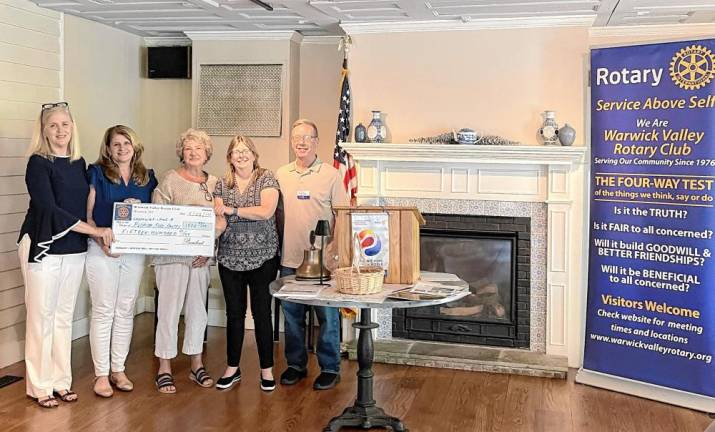 Rotary President Neil Sinclair presents a check to Florida Food Pantry Director Beth Maas and volunteer Cindi Codi, alongside Greenwood Lake Food Pantry representatives Pat Albers and Pat Nolan.