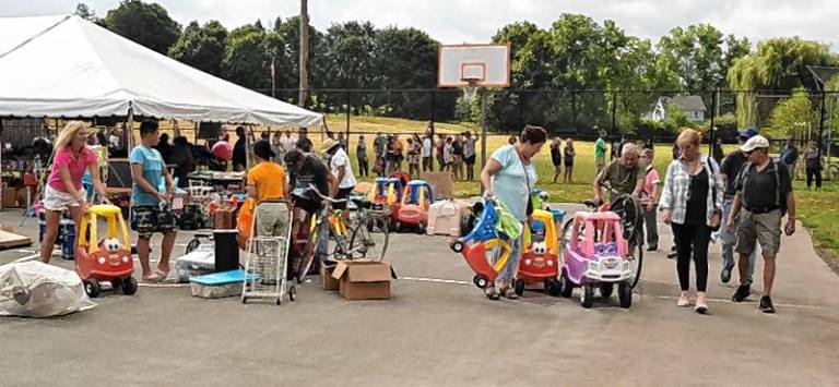 Community members check out the selection of kids’ vehicles.