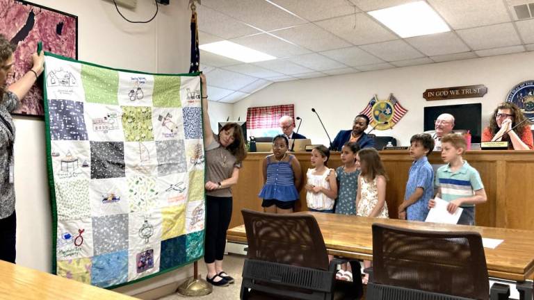 Greenwood Lake Elementary School students from Laurie Sanford’s third-grade class present their centennial quilt to the Greenwood Lake Board of Trustees on May 22.
