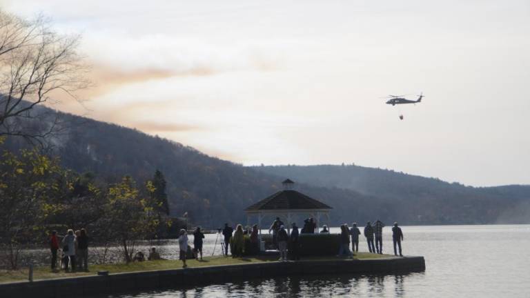 A crowd watches as one of the helicopters in use hauls water to the Jennings Creek Fire on Nov. 17.